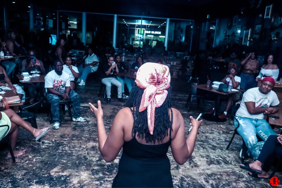 A performer engaging a seated crowd from the stage